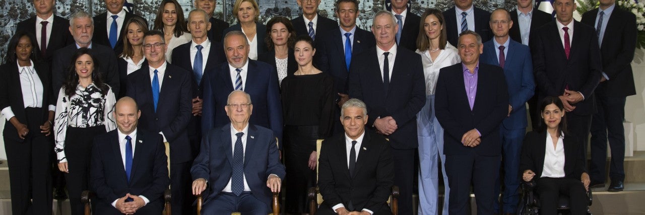 Photo of Israeli Prime Minister Naftali Bennett, Reuven Rivlin, and Yair Lapid, with other members of Knesset