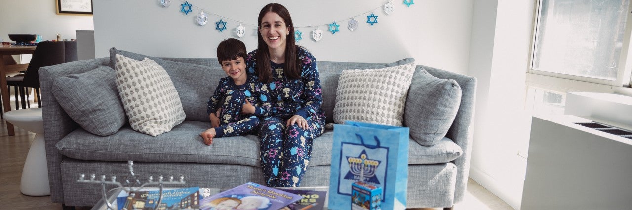 photo of Rabbi Yael Bucheler with child with kippa in hanukkah pajamas