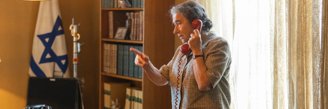 Helen Mirren standing in front of a desk, on the phone, pointing a finger, in her role as Golda Meir in Bleecker Street/ShivHans Pictures -GOLDA. Credit: Sean Gleason, Courtesy of Bleecker Street/ShivHans Pictures