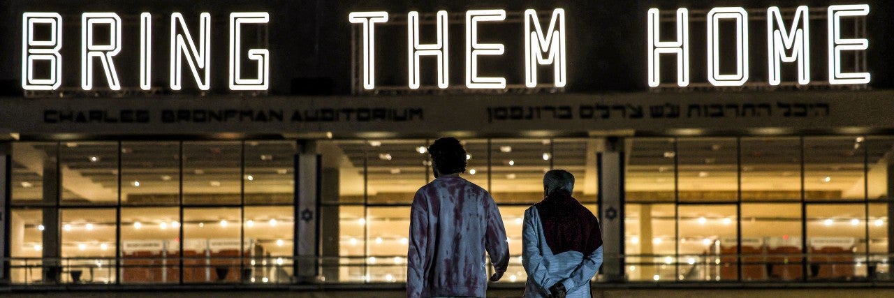 TOPSHOT - A neon sign reading "BRING THEM HOME", referring to the Israeli hostages held in Gaza since the October 7 attacks, is displayed atop the Charles Bronfman Auditorium (Heichal HaTarbut) at HaBima Square in Tel Aviv on December 9, 2023. Israeli forces have encircled major urban centres in the Gaza Strip as they seek to destroy Hamas over its unprecedented attack in October when militants broke through Gaza's militarised border to kill around 1,200 people and seize hostages, 138 of whom remain captive