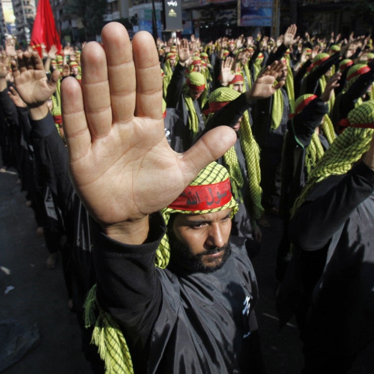 Hezbollah militants standing in salute