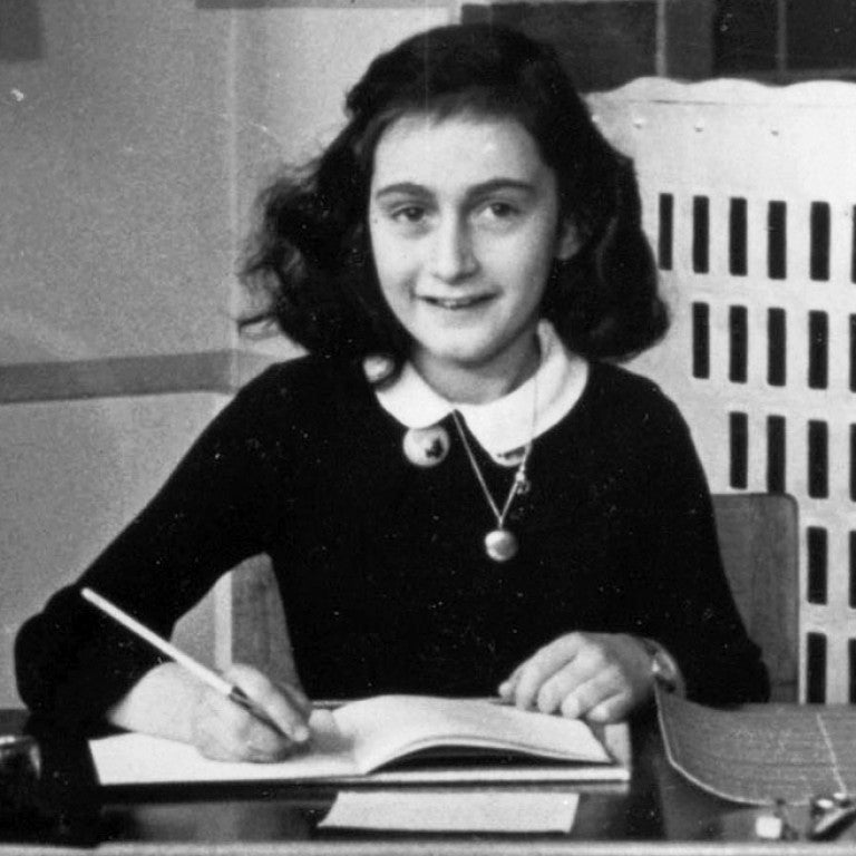 Photo of Anne Frank at her desk