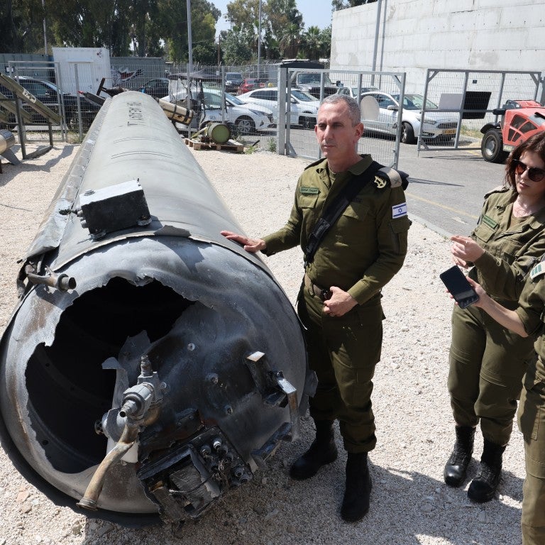 Israeli military spokesman Rear Admiral Daniel Hagari (C) and other members of the Israeli military stand next to an Iranian ballistic missile which fell in Israel on the weekend, during a media tour at the Julis military base near the southern Israeli city of Kiryat Malachi on April 16, 2024. Iran carried out an unprecedented direct attack on Israel overnight April 13-14, using more than 300 drones, cruise missiles and ballistic missiles.